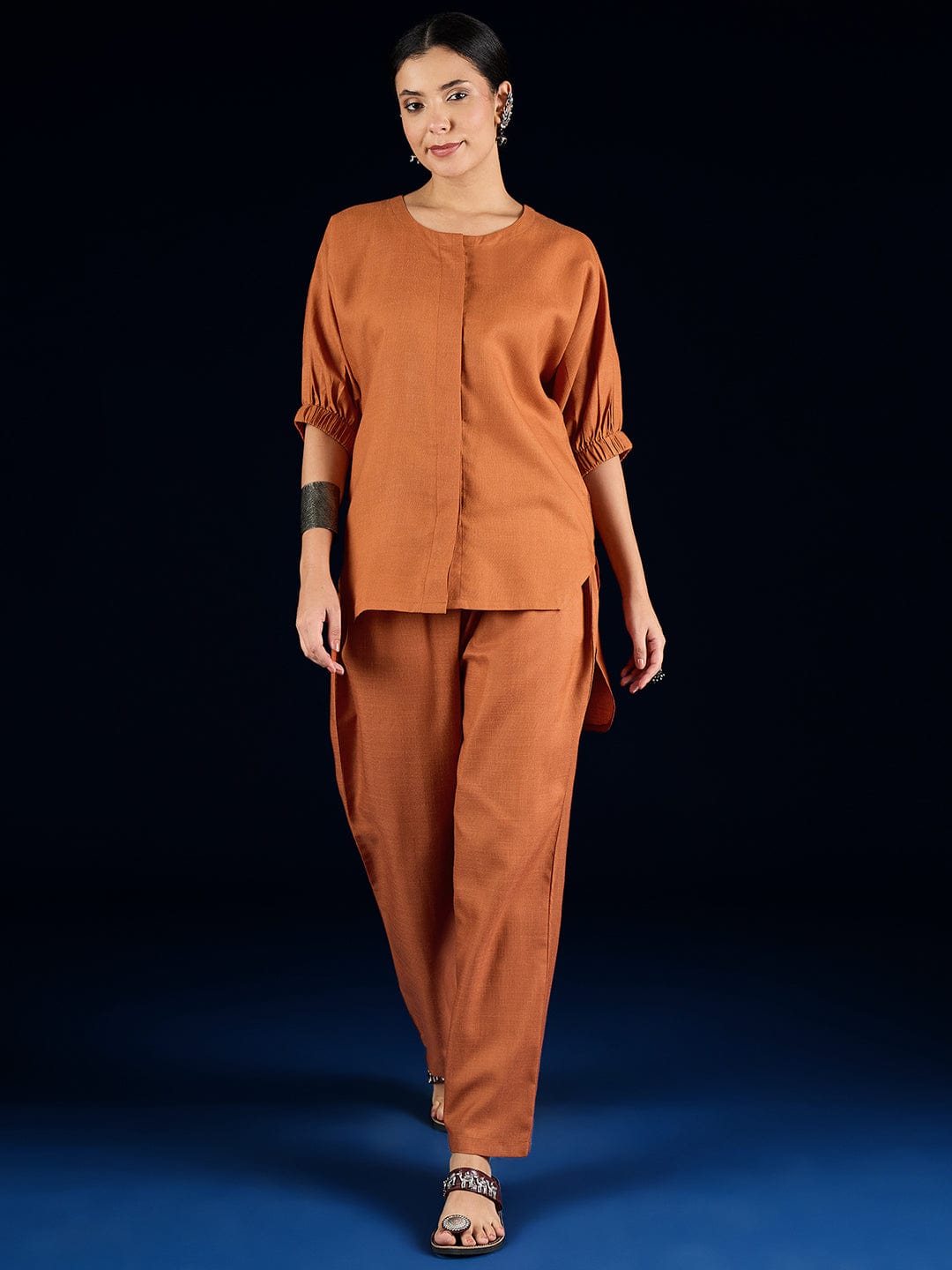 The Kurti Collection Rust Straight-Fit Shirt With Puff Sleeves And A Round Neck, Paired With Solid Ankle-Length Straight-Fit Trousers.
